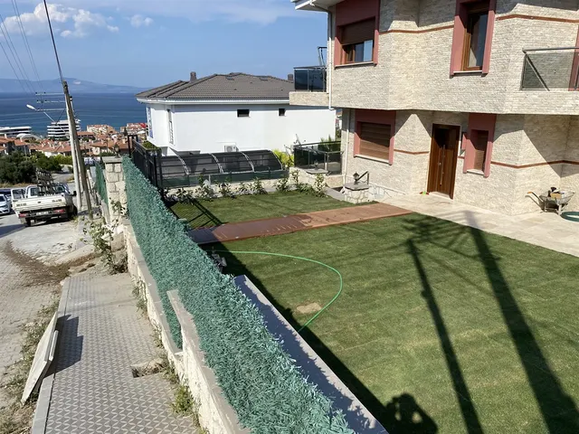 Aksoy Villası yenilenmiş çim bahçe ve ahşap deck yürüyüş yolu - deniz manzaralı